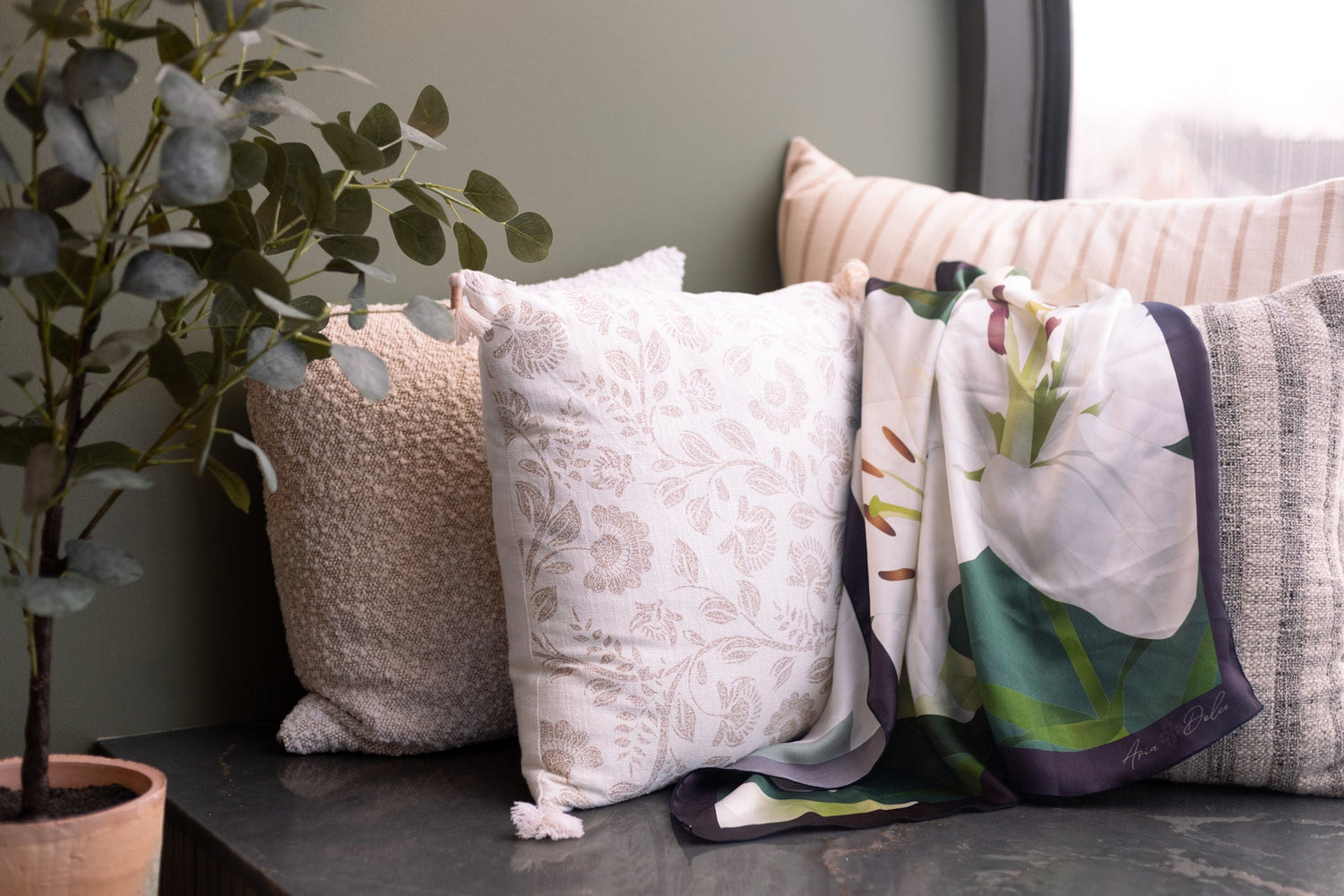 green and white silk scarf draped across pillows