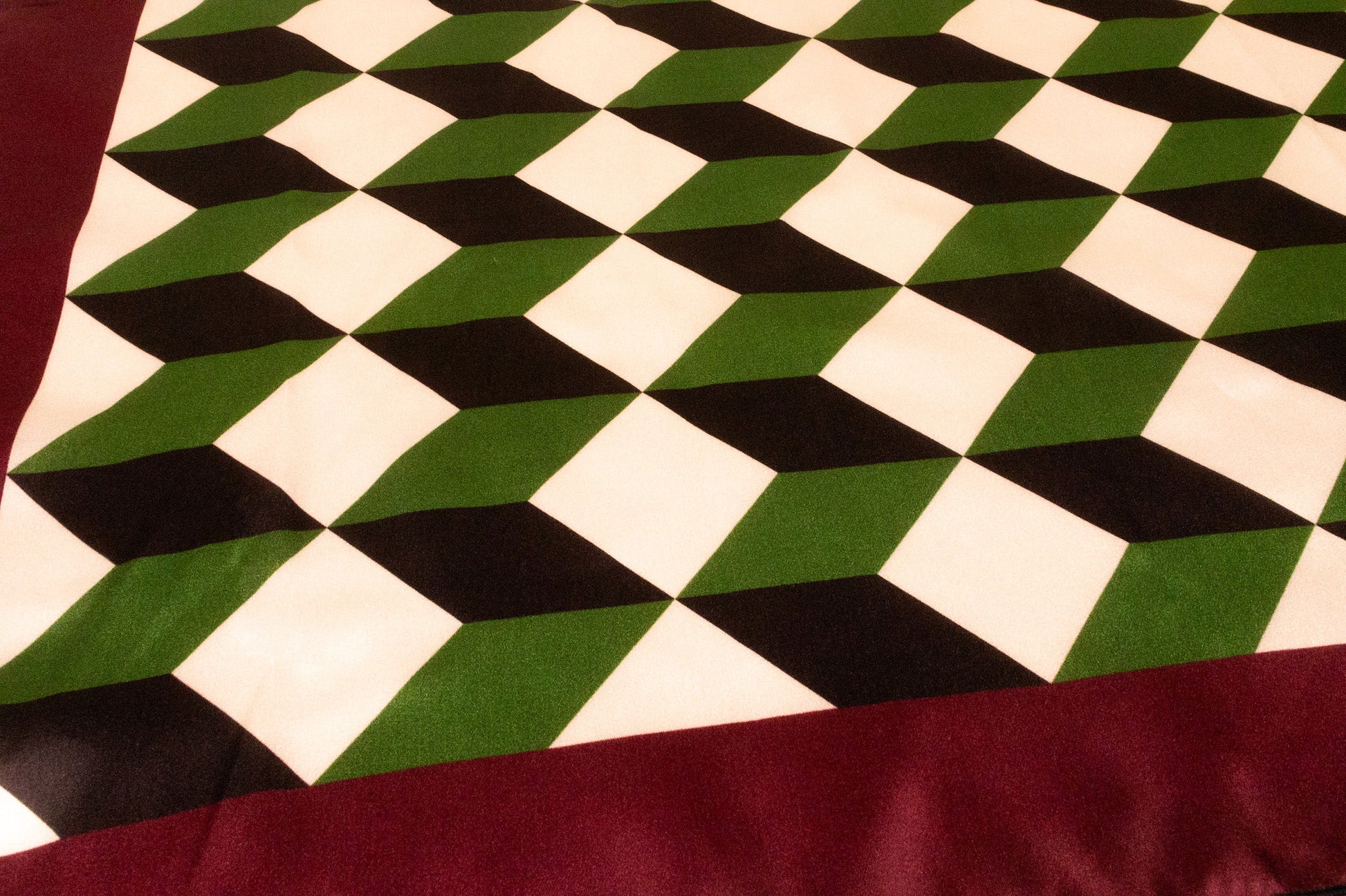Close-up detail of geometric chevron pattern on luxury silk charmeuse
