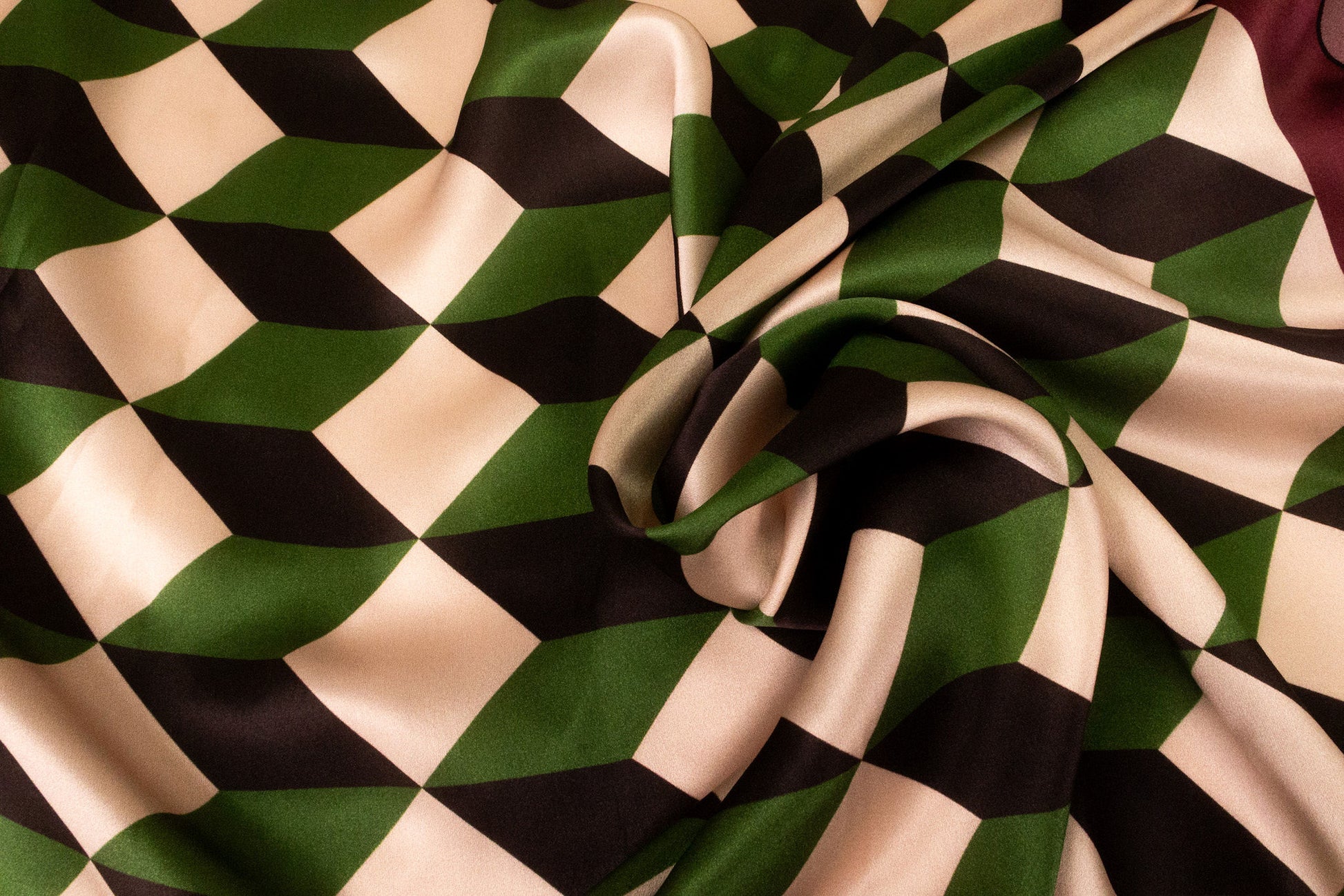 Close-up of geometric chevron silk scarf twisted to display the cathedral-inspired pattern