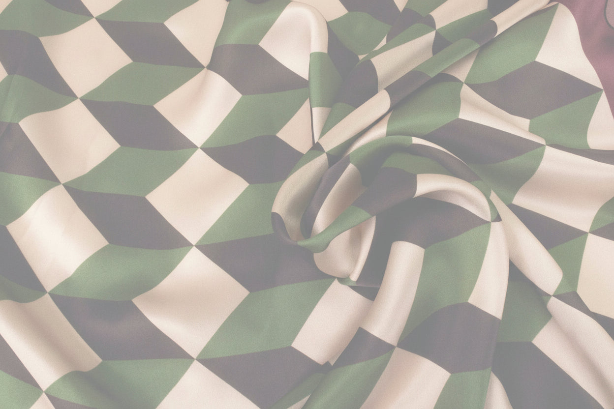 green, black and cream geometric silk scarf swirled in the center laying flat.