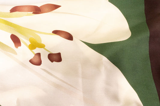 Close-up detail of lily flower print on luxury silk charmeuse fabric
