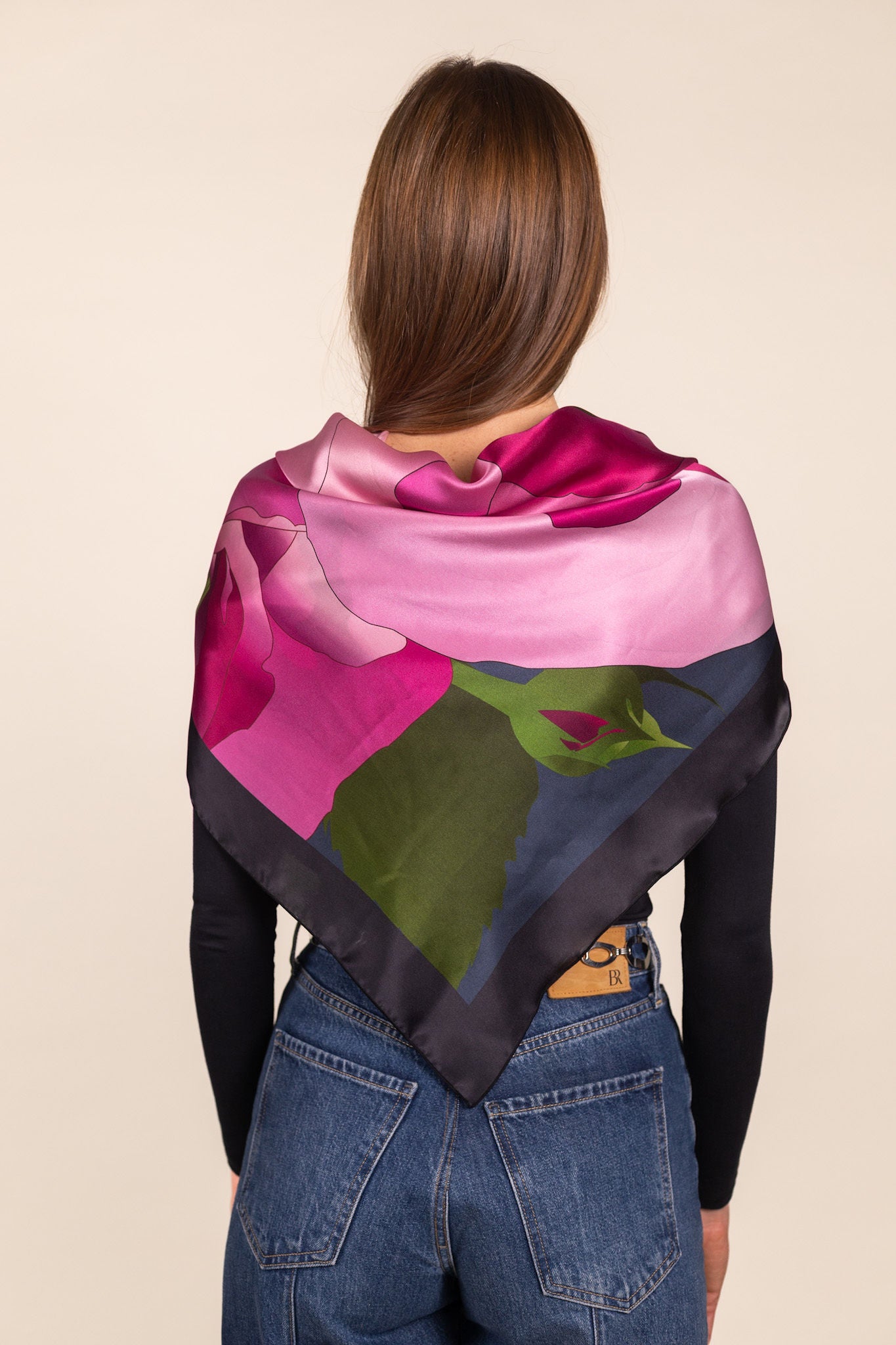 Woman wearing pink floral silk scarf styled as neck accent
