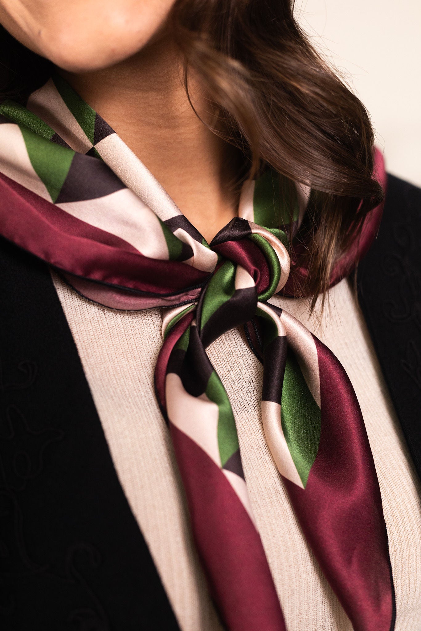 Woman wearing geometric silk scarf with chevron pattern as neck accent