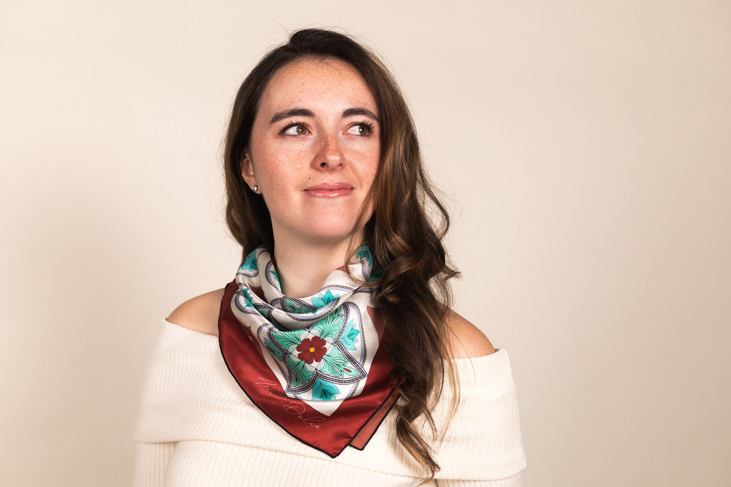 Turquoise silk scarf worn around neck showing Mediterranean mosaic pattern