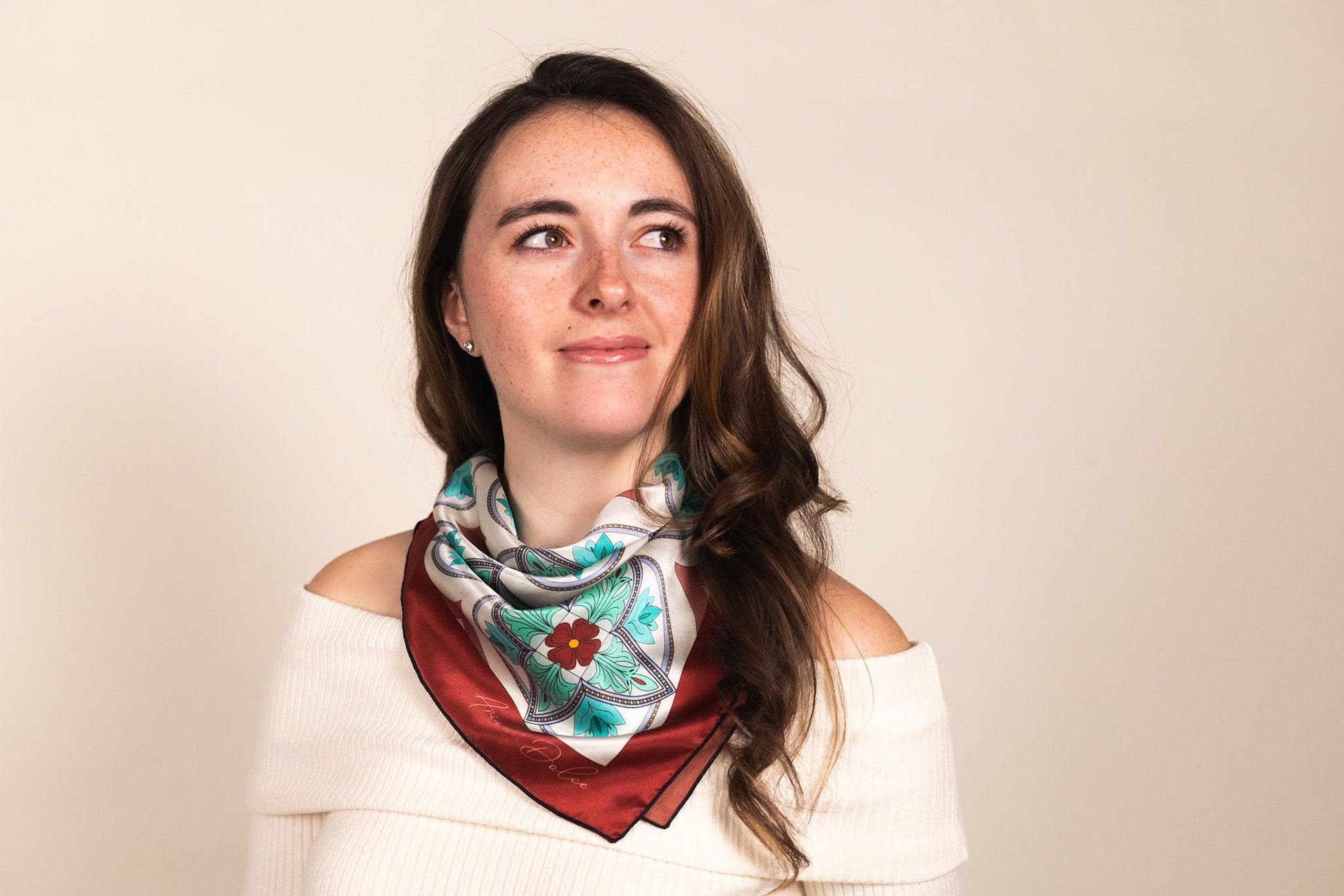 Turquoise silk scarf worn around neck showing Mediterranean mosaic pattern