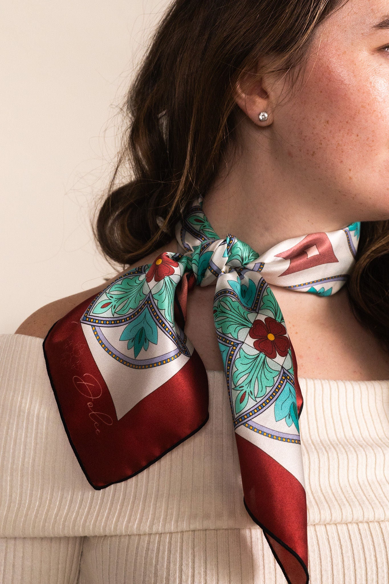 Mosaic pattern scarf in turquoise tied at neck for elegant accent