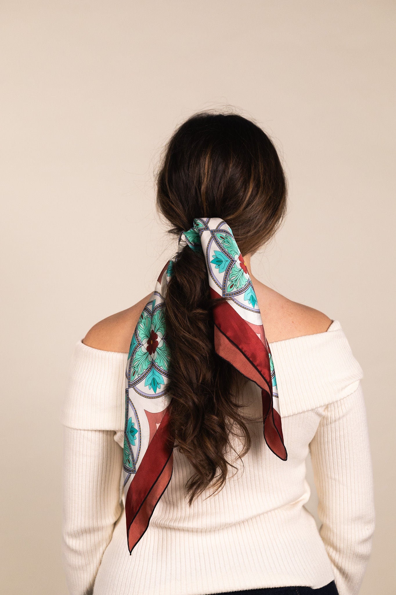 Turquoise mosaic scarf tied in as hair accessory 