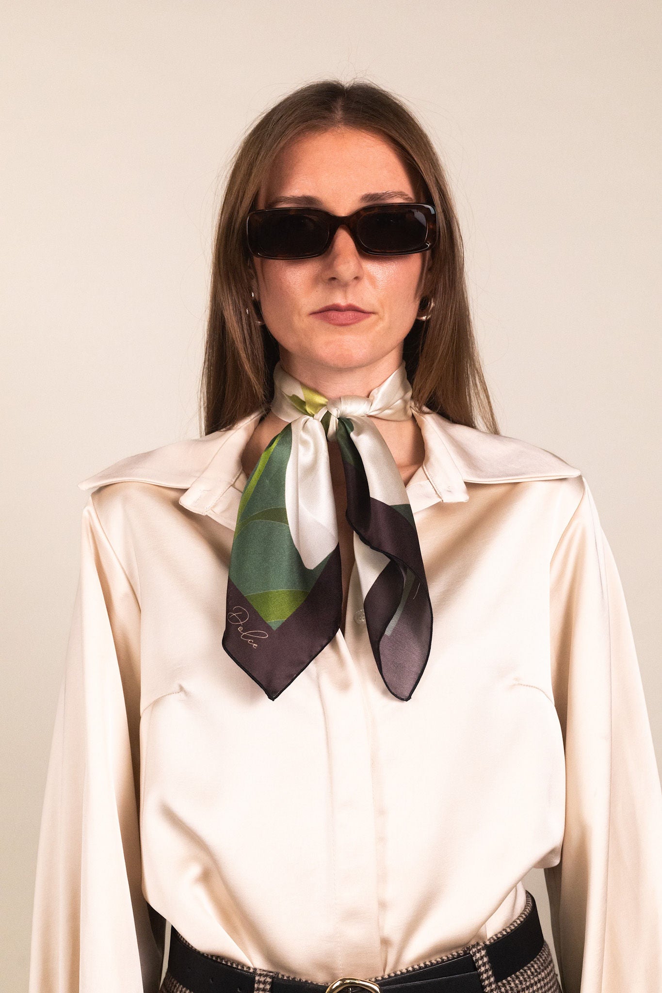 Woman wearing green and white lily print silk scarf as neck accent